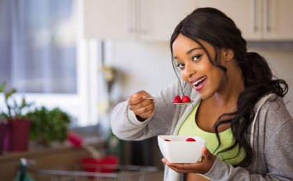 woman eating strawberries out of a bowl