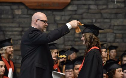 father helping daughter with graduation cap